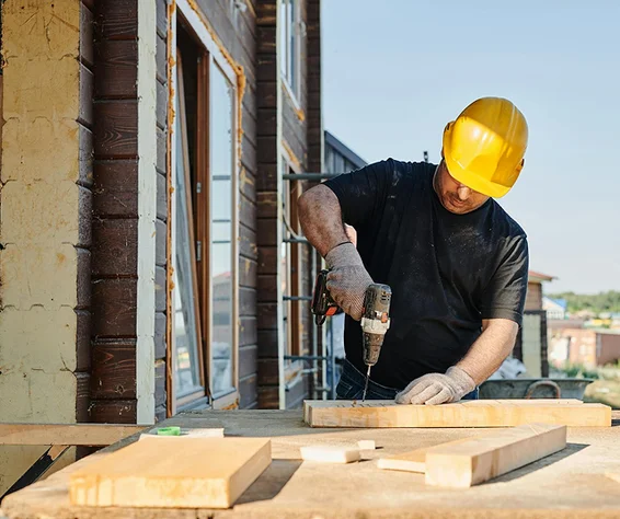man drilling a block of wood