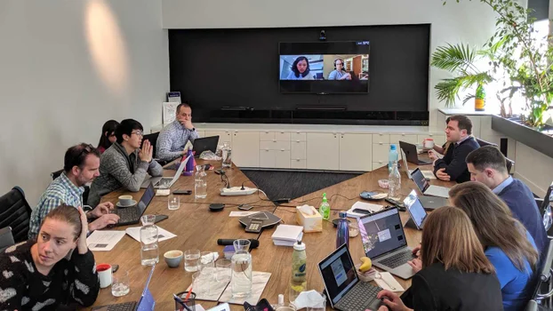 People in a workshop with remote participants on screen