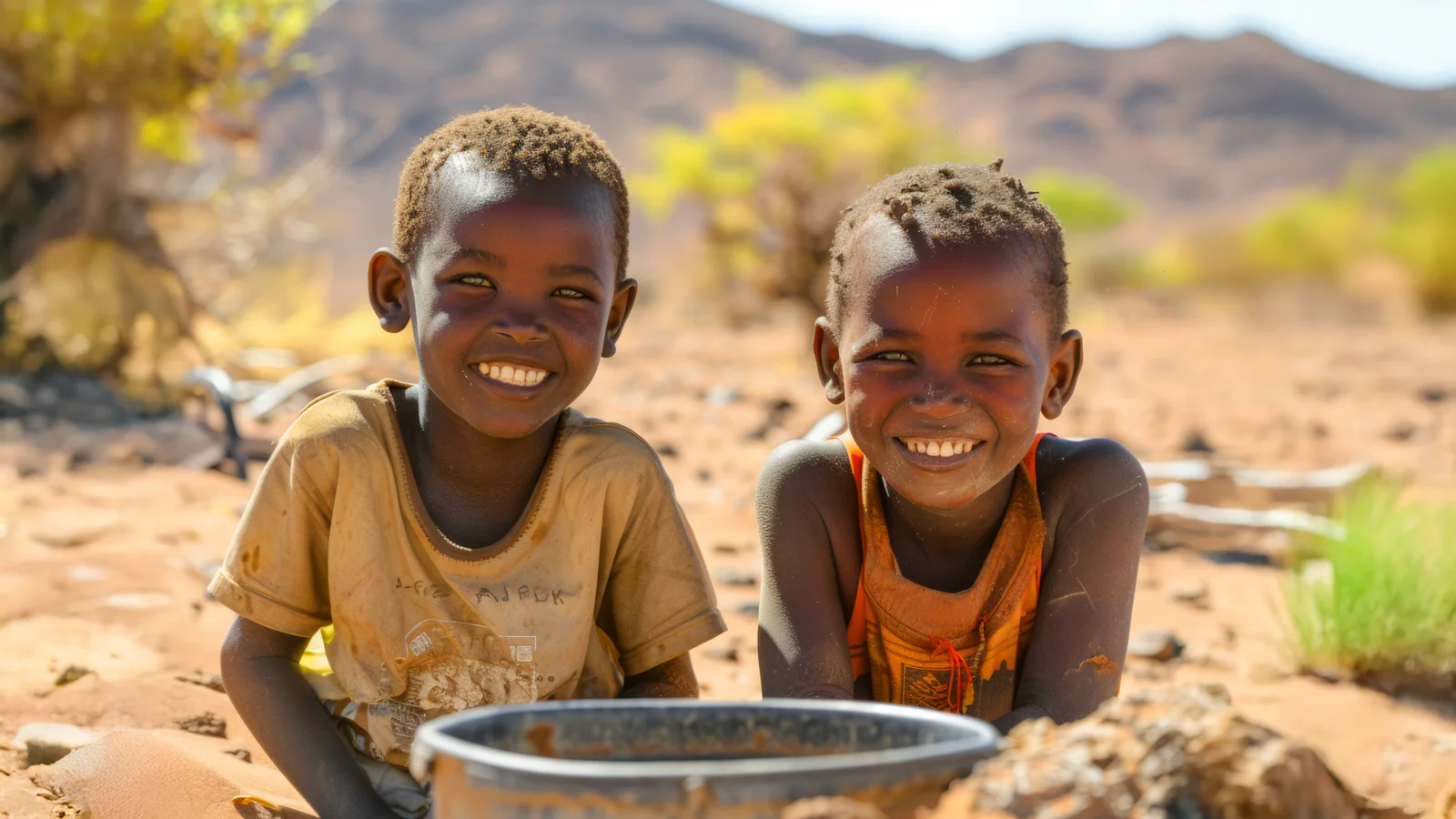 Two young children in a desert holding a bowl
