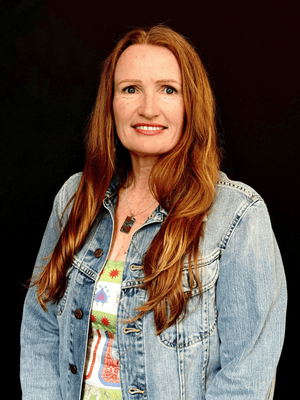 Red haired lady, smiling on a black background