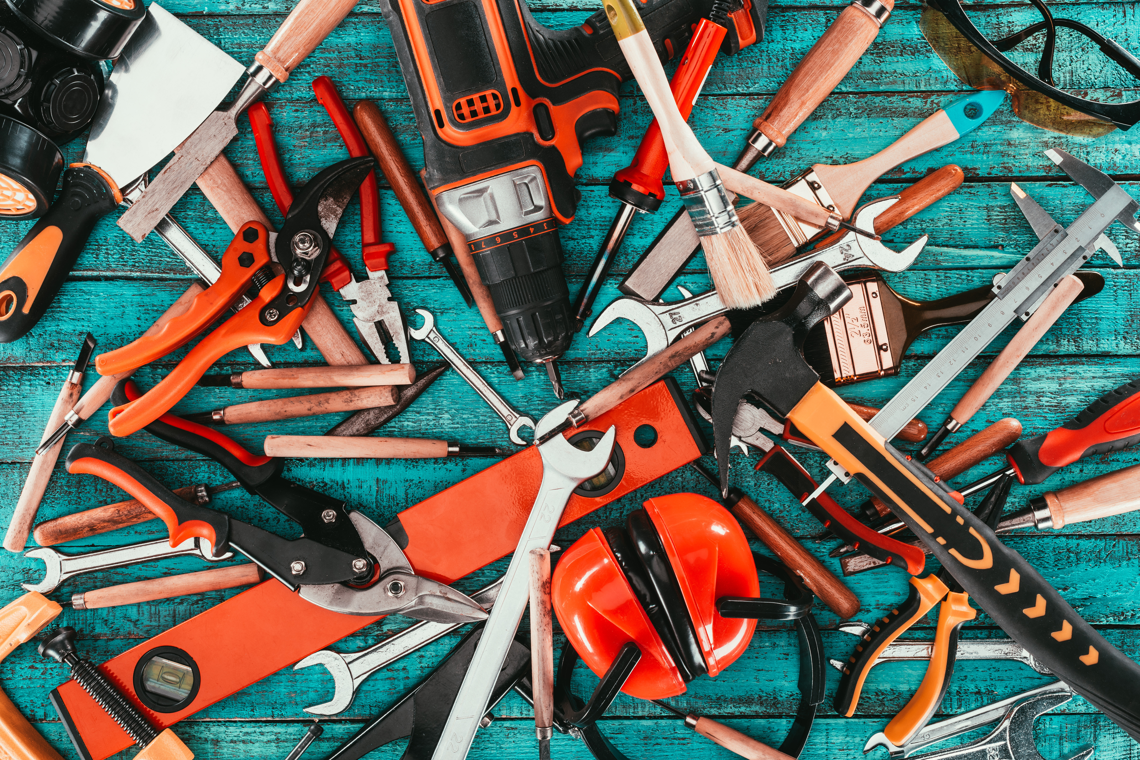Various set of tools laying flat on table in disorganized fashion