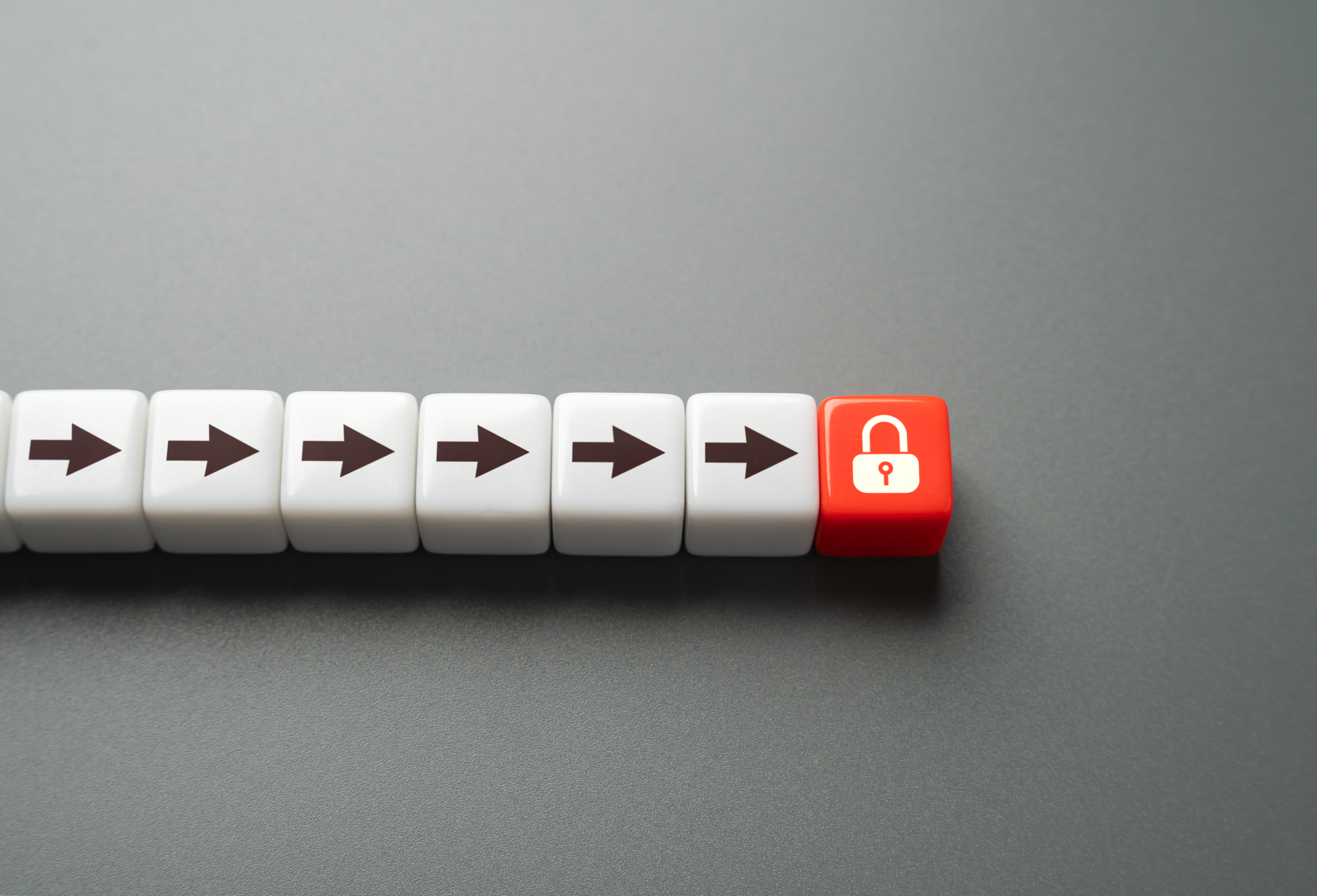 White dices with arrows in a row pointing in one direction and then red dice with lock at end blocking.