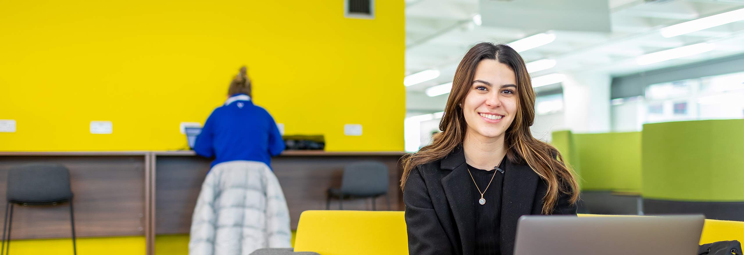Student smiling and working on laptop