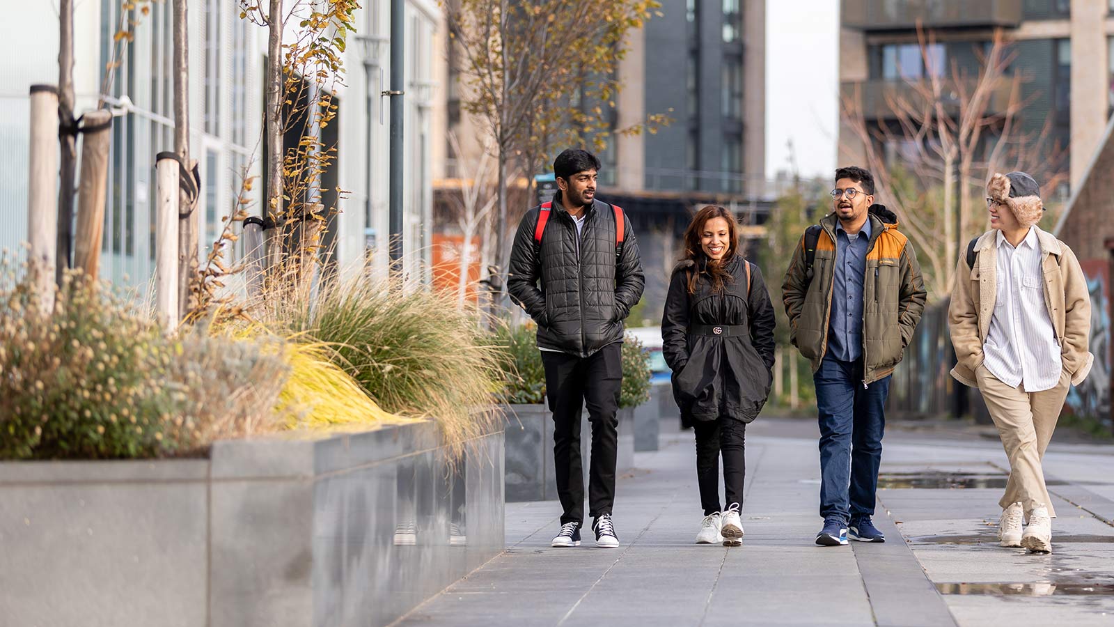 Four students walking together outside campus