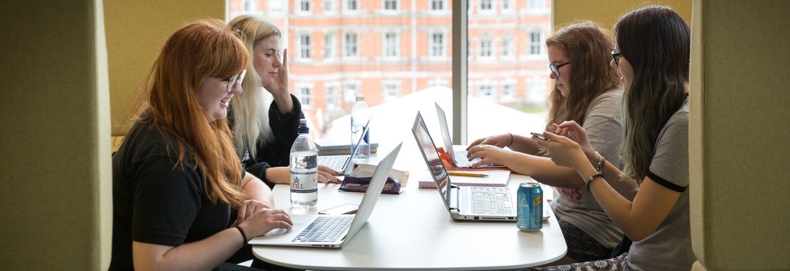 Students working on laptops at a table