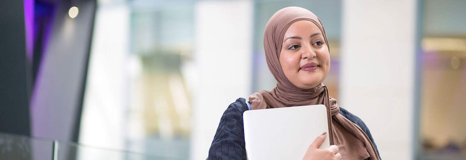 A student holding a laptop