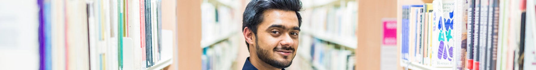 Student smiling at camera in library