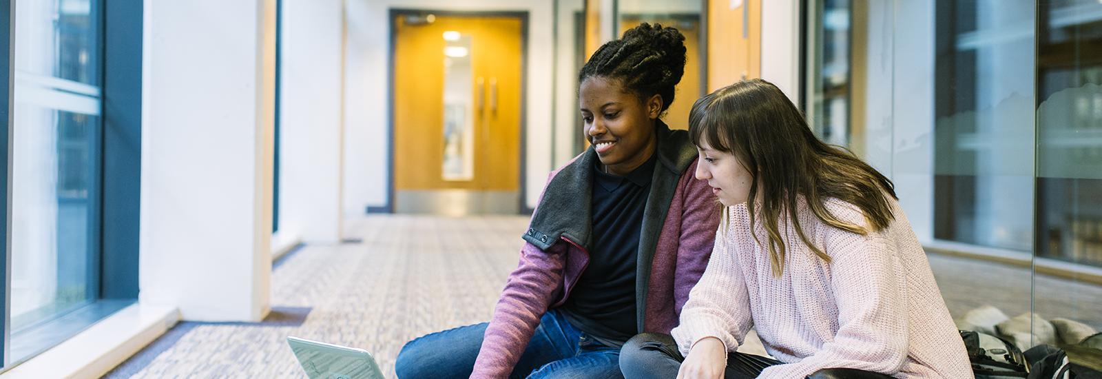 Leeds University students reading off of a laptop
