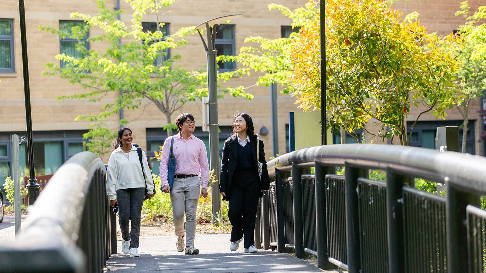 Three students walking together on a sunny day. 
