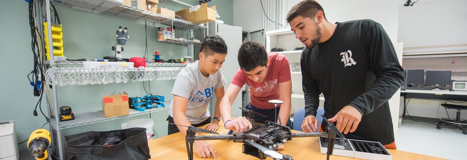 Three students working together in a classroom.