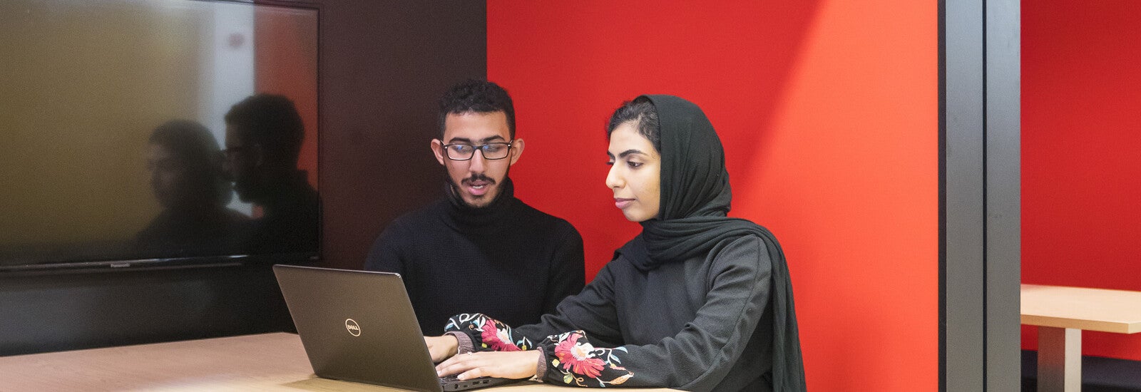 Two students working together in the common area