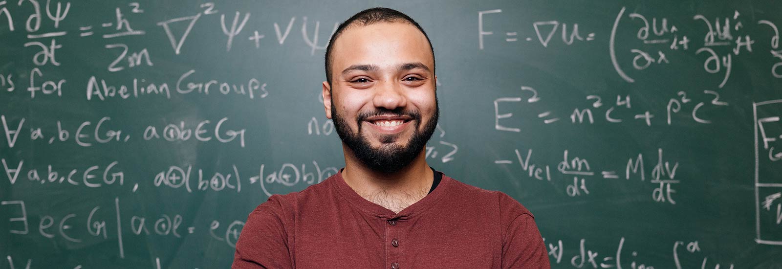 在黑板前微笑的萨里大学学生