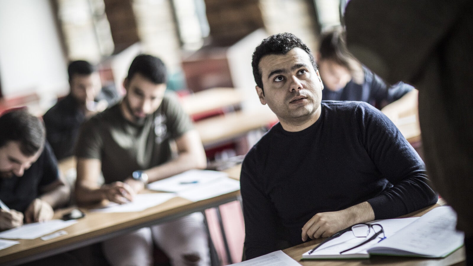 A student looking up at a tutor in class