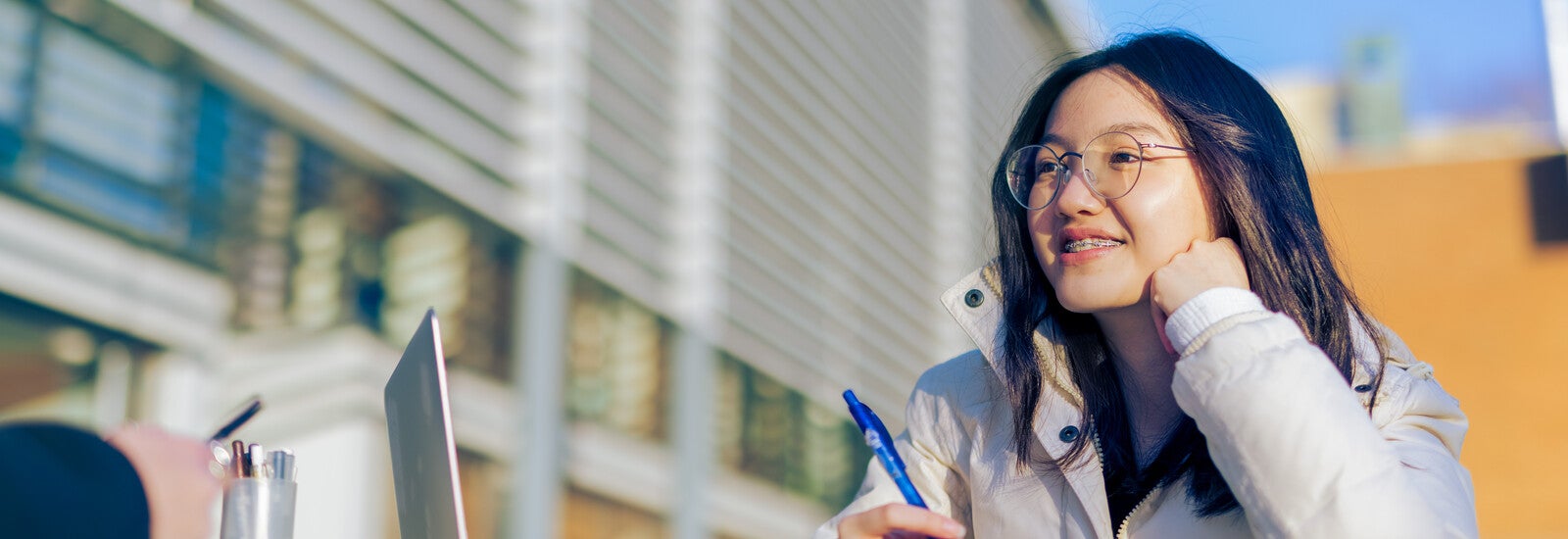 Student sitting at table outside campus