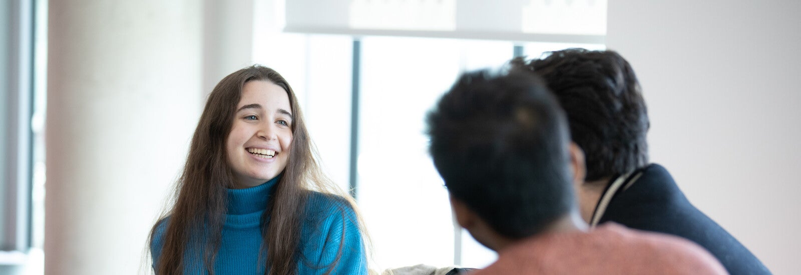 Three students sitting and socialising on campus