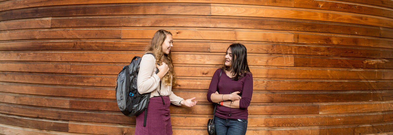 Students talking and leaning against wall