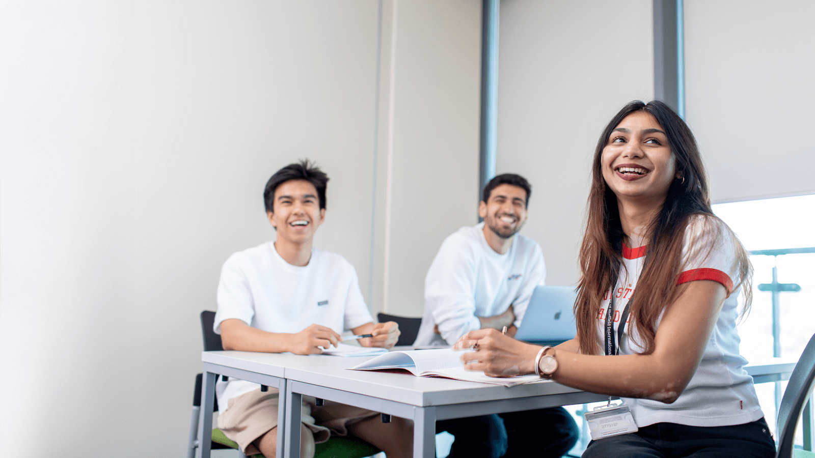 A graduate in a crowd smiling at the camera