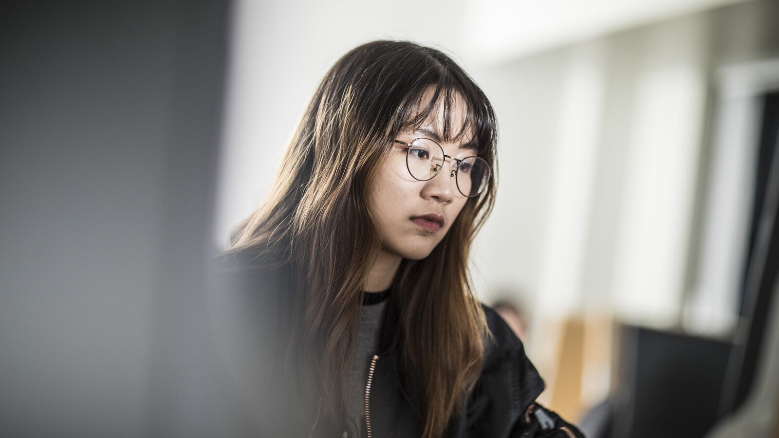 A Huddersfield University - London student on a computer