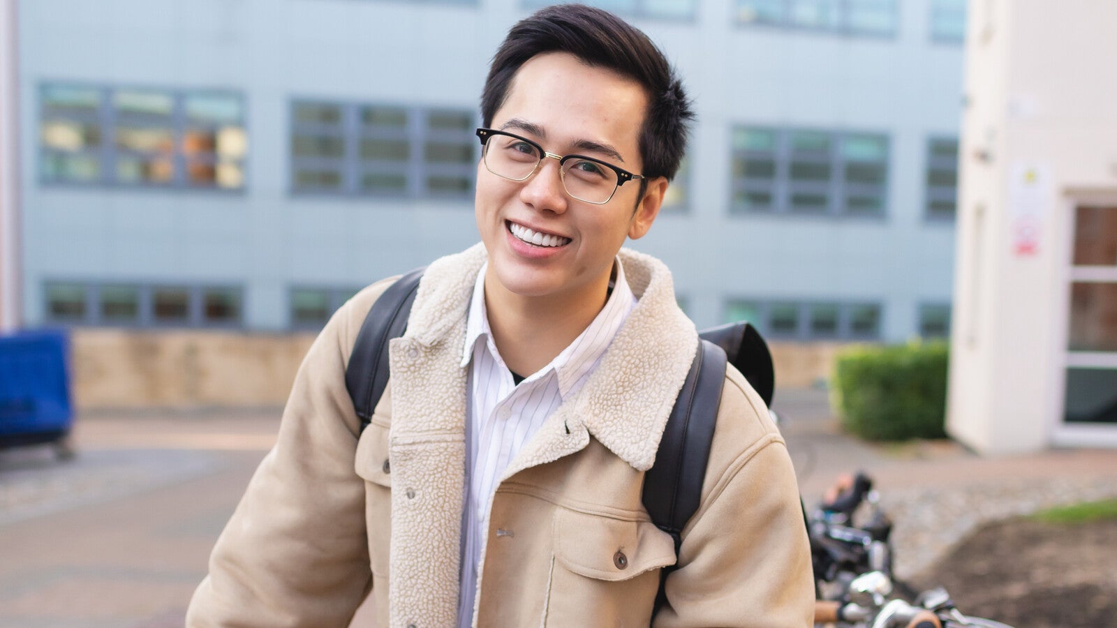 A student smiling outside campus