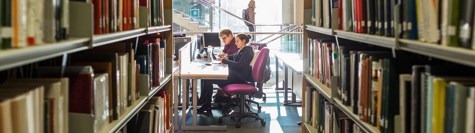 Students studying in library on laptops