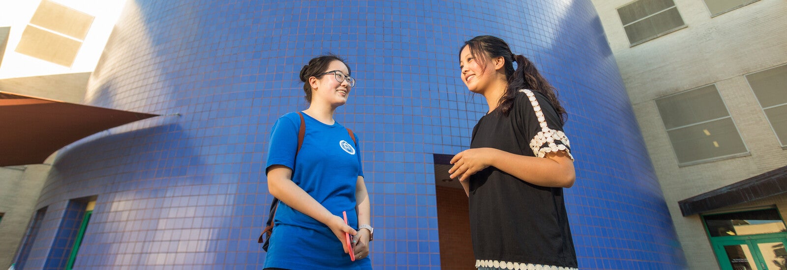 Students smiling outside campus building