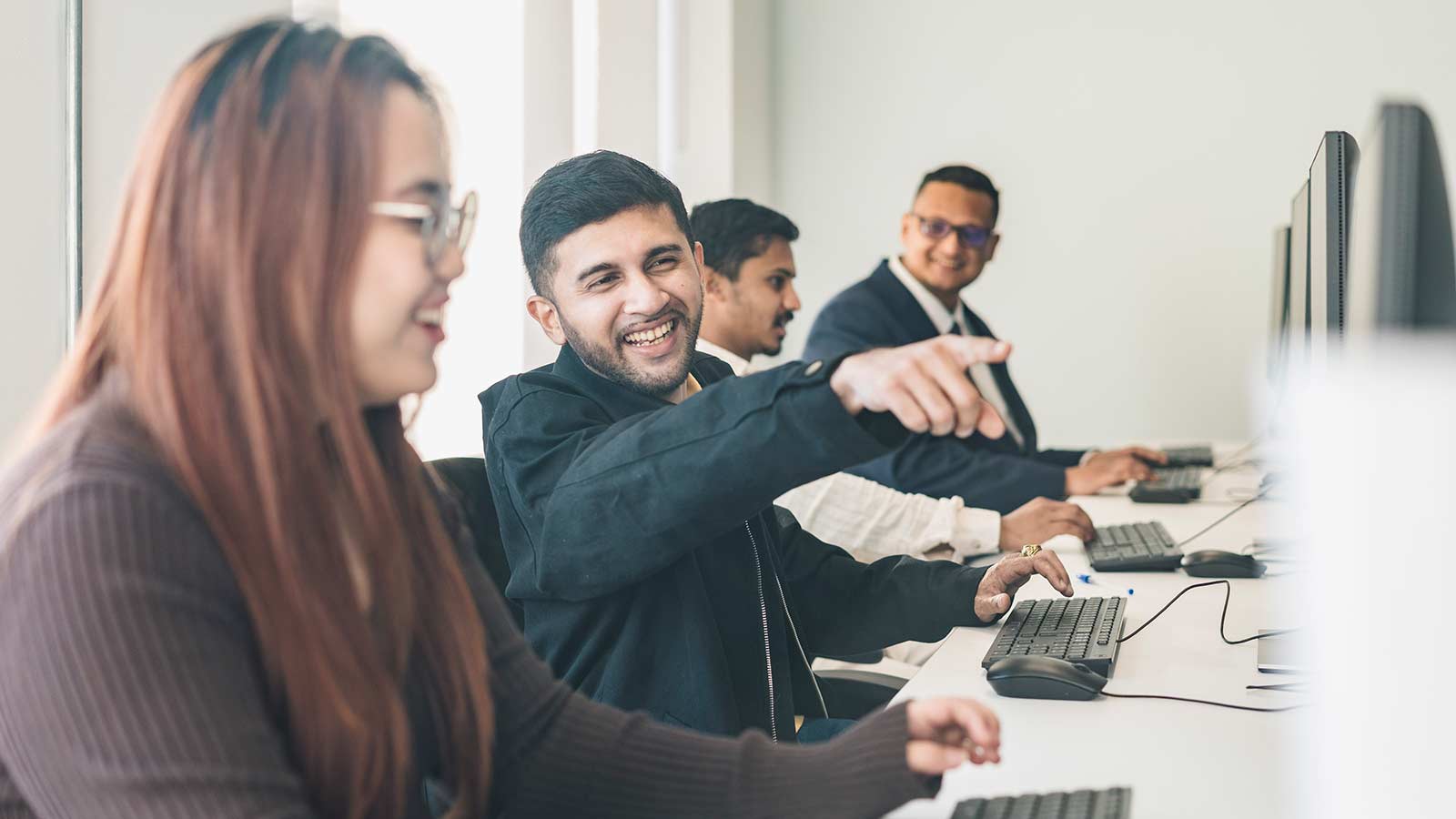 A student in class listening while sitting at a computer