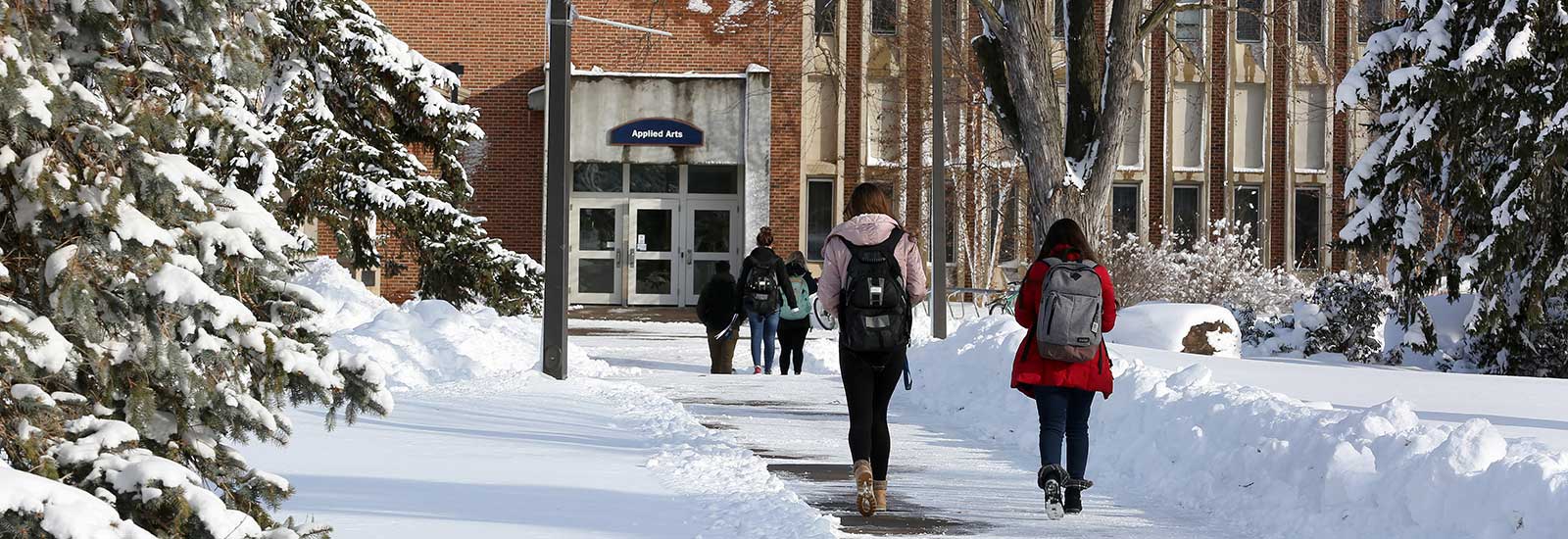 Students walking towards campus building in the snow