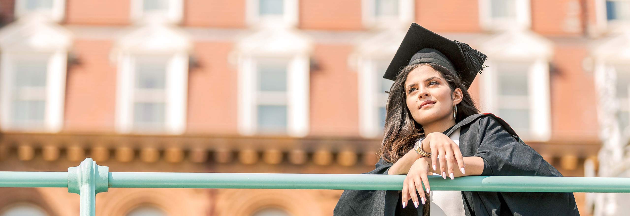 Graduate leaning on railings