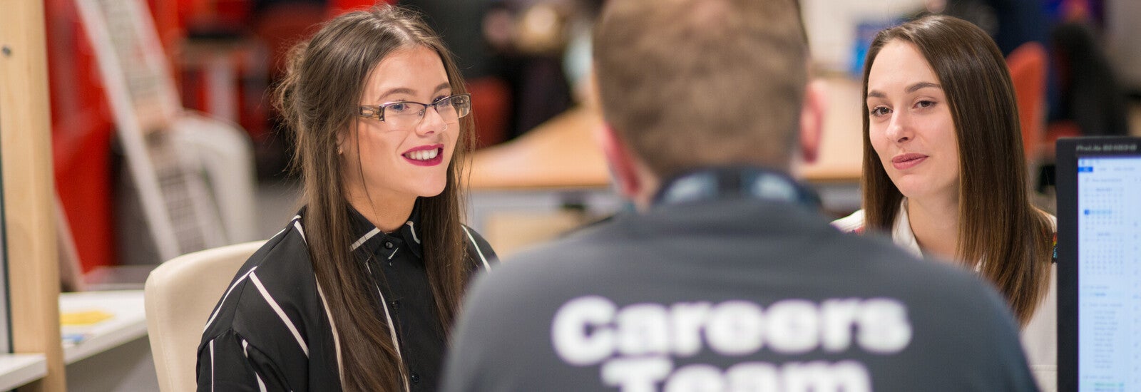 与职业顾问坐在一起的两名学生