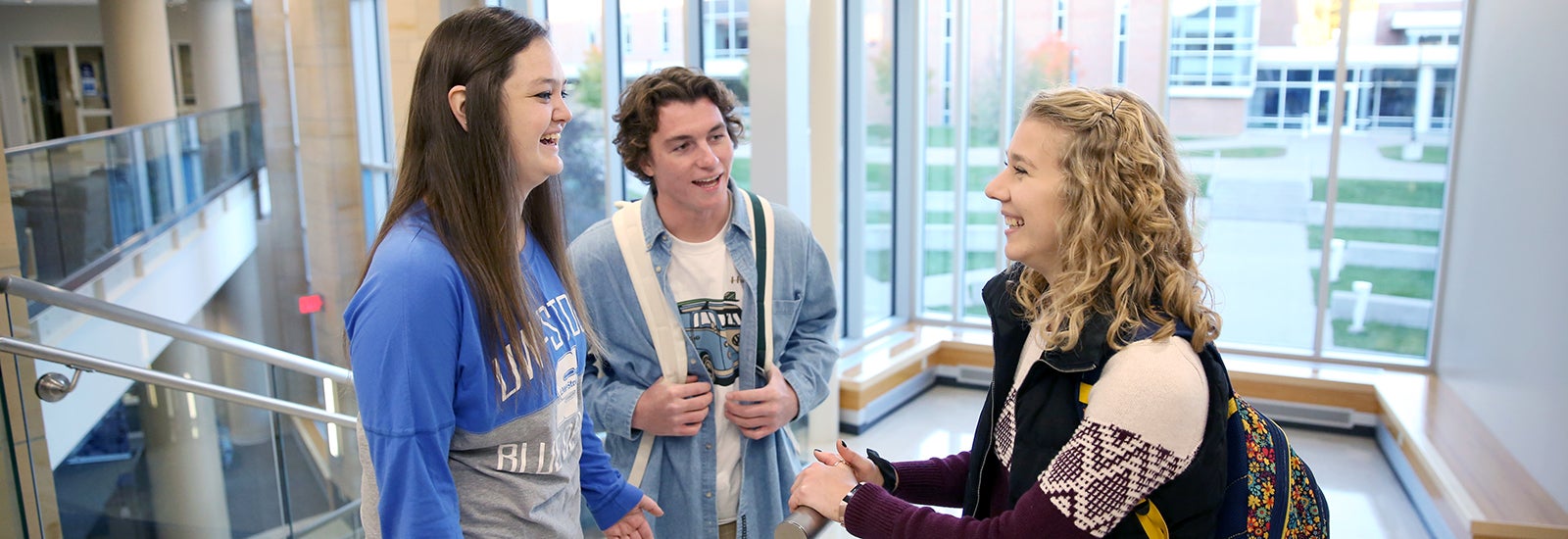 Three students talking inside campus