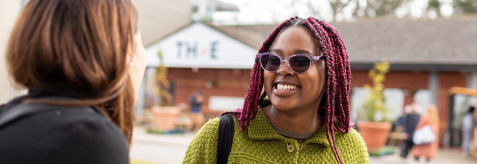 An international student smiling and talking with a friend