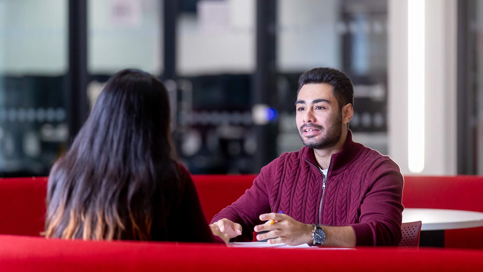 坐在阅览室里面带微笑的学生
