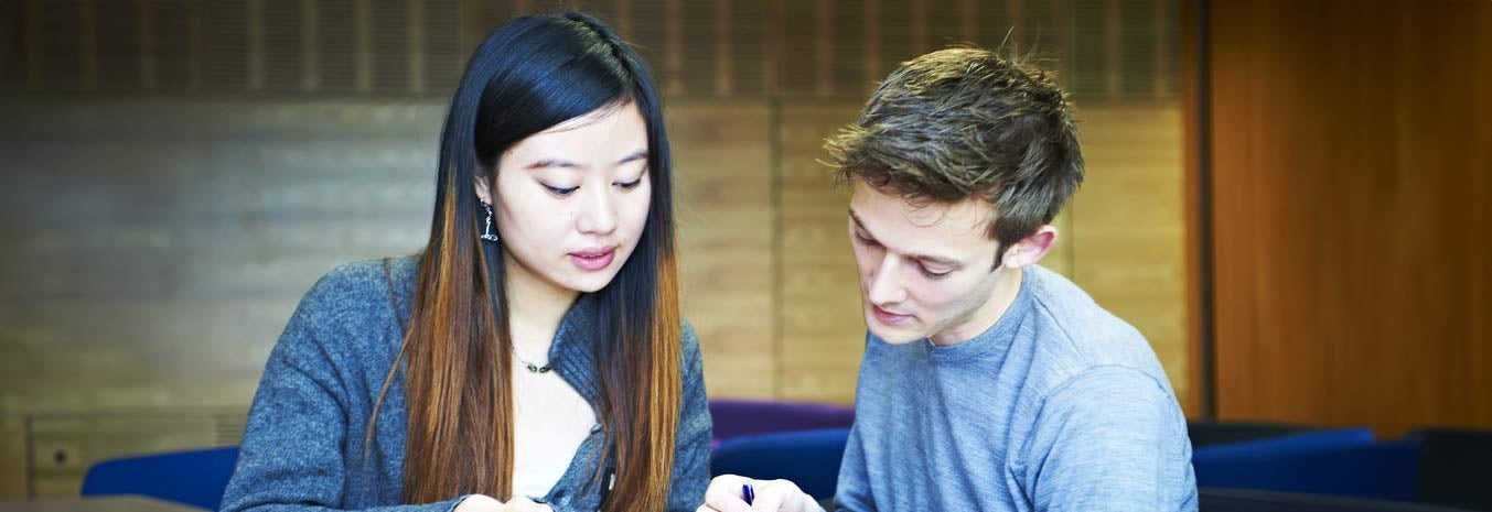 Two students looking at a piece of paper together