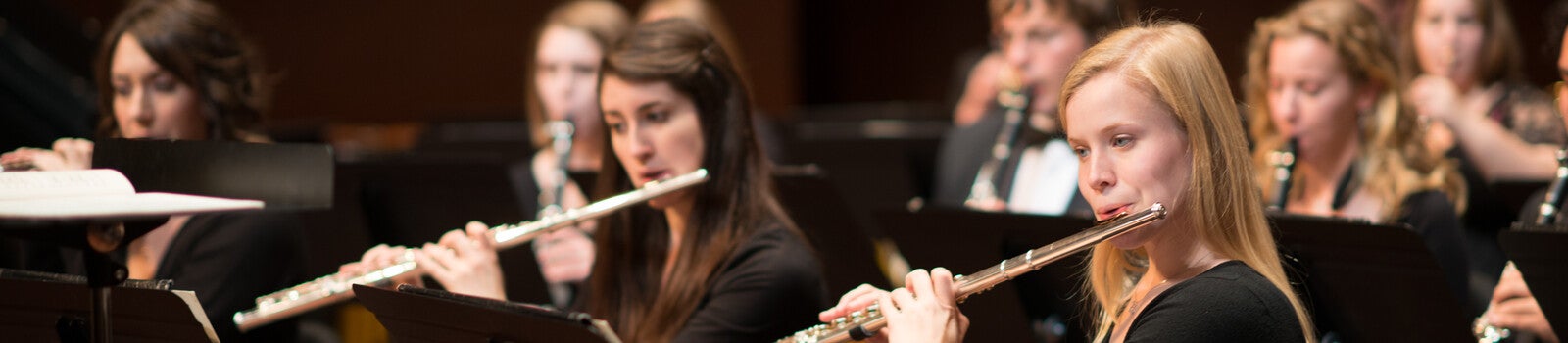 Students in orchestra playing flutes