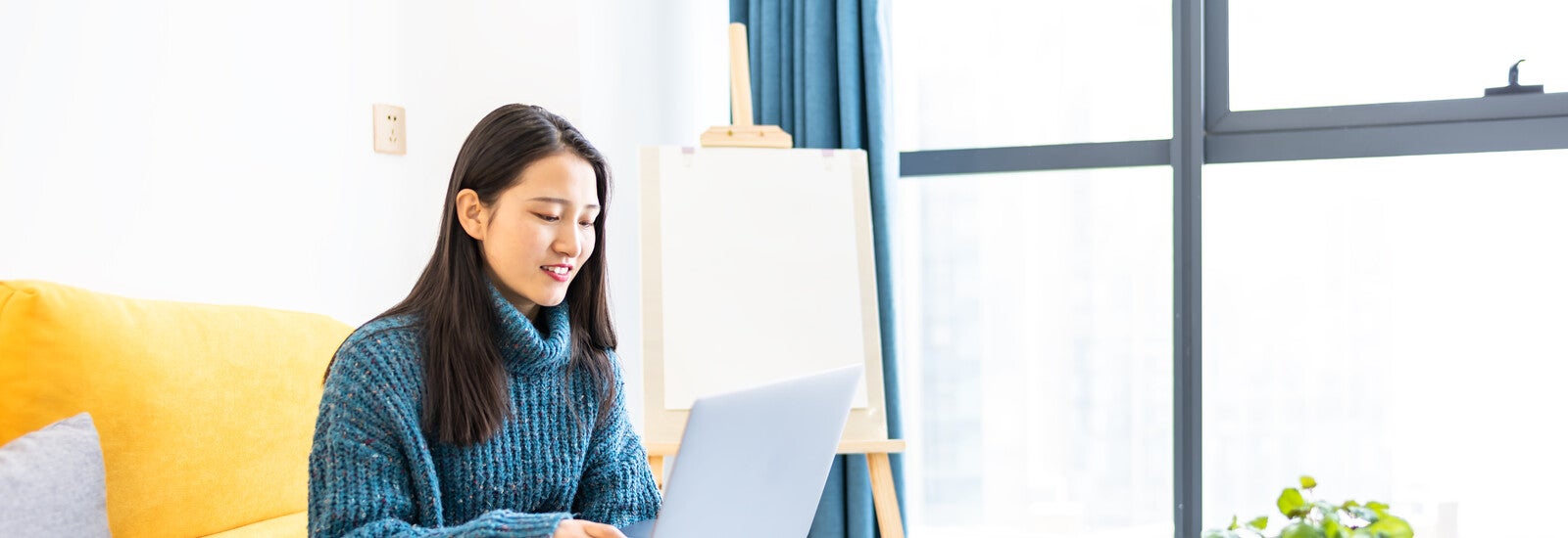 A student using a laptop in their home.