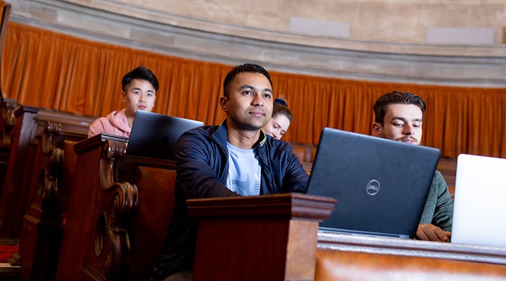 在演讲厅使用笔记本电脑的学生