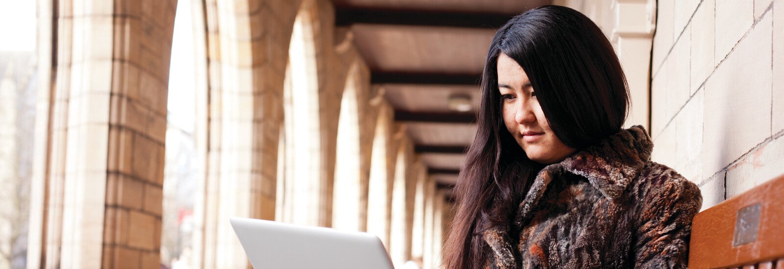 An international student working on her laptop