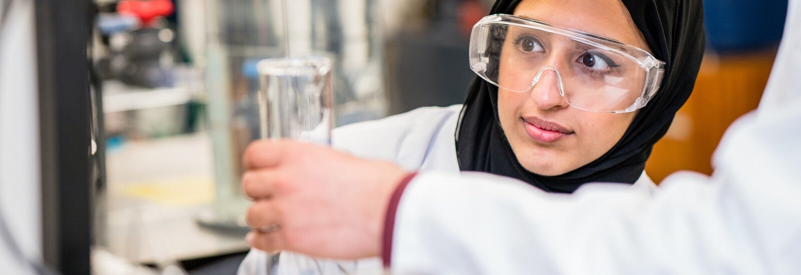 A student in a lab wearing goggles