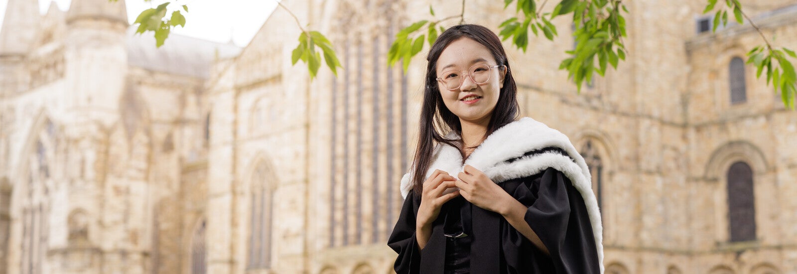 Durham graduate smiling outside campus
