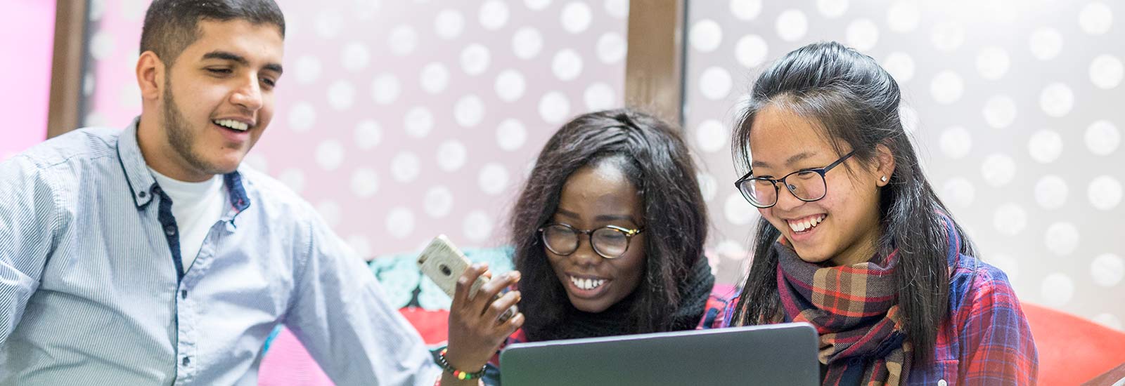 Students using a phone and laptop