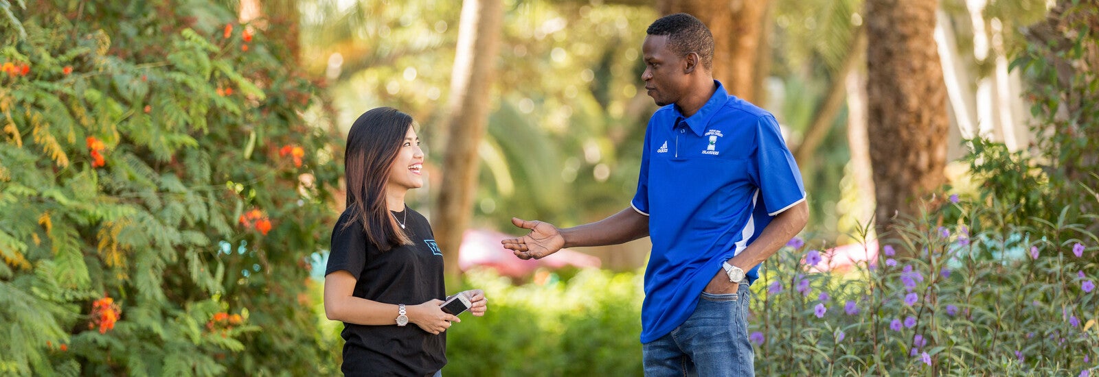 Students talking outside by palm trees