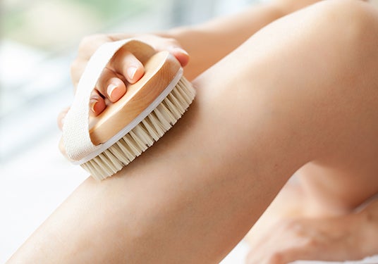 Woman dry brushing her leg