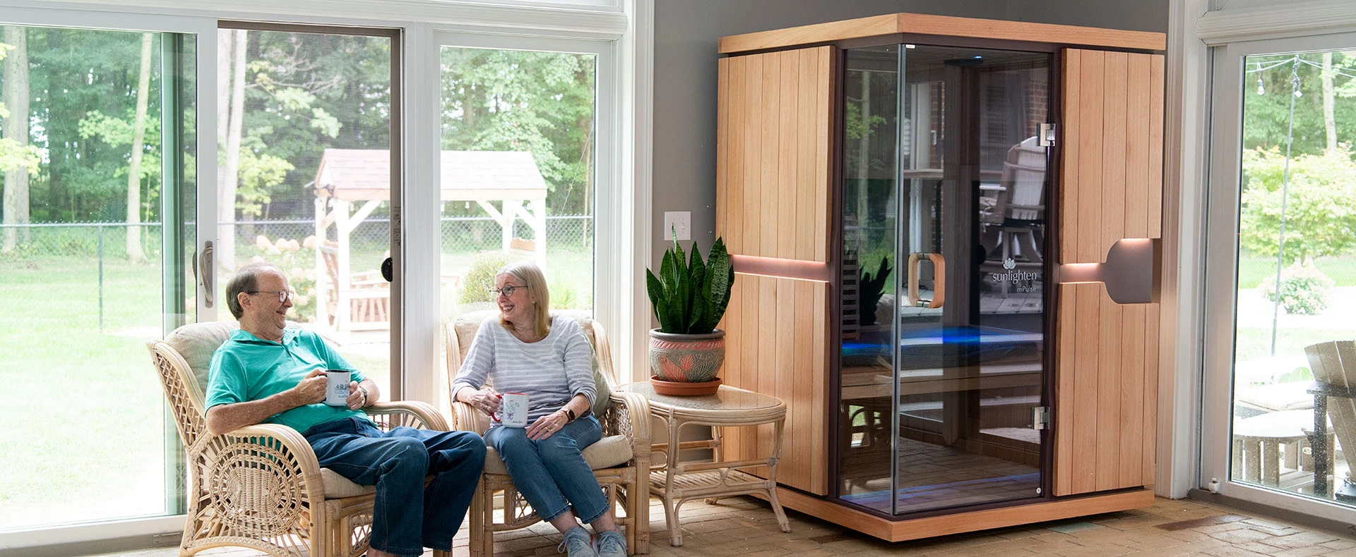 A man and woman sitting next to their Sunlighten infrared sauna