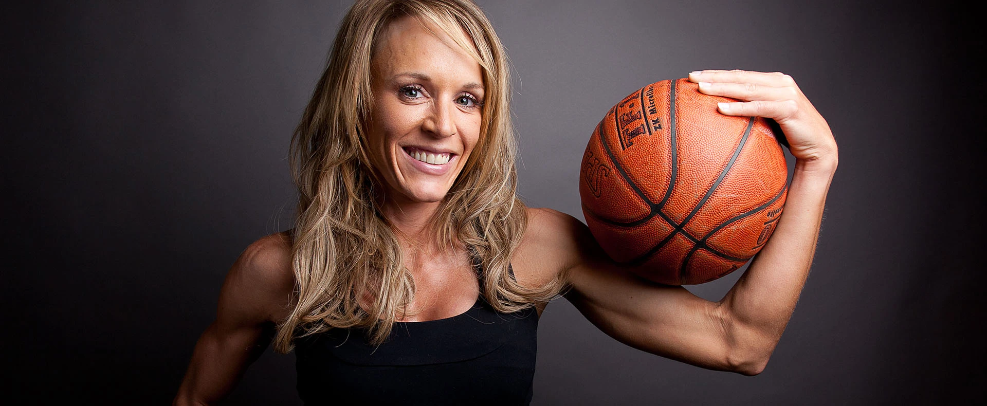 Jackie Stiles posing with a basketball