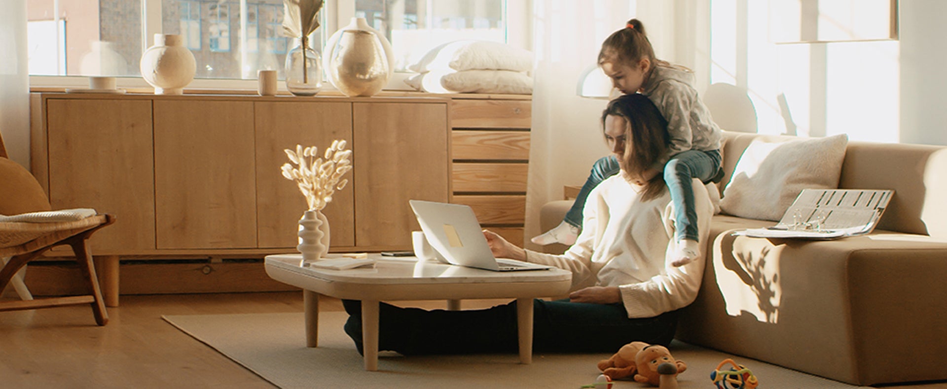 Woman working at home with daughter on her shoulders