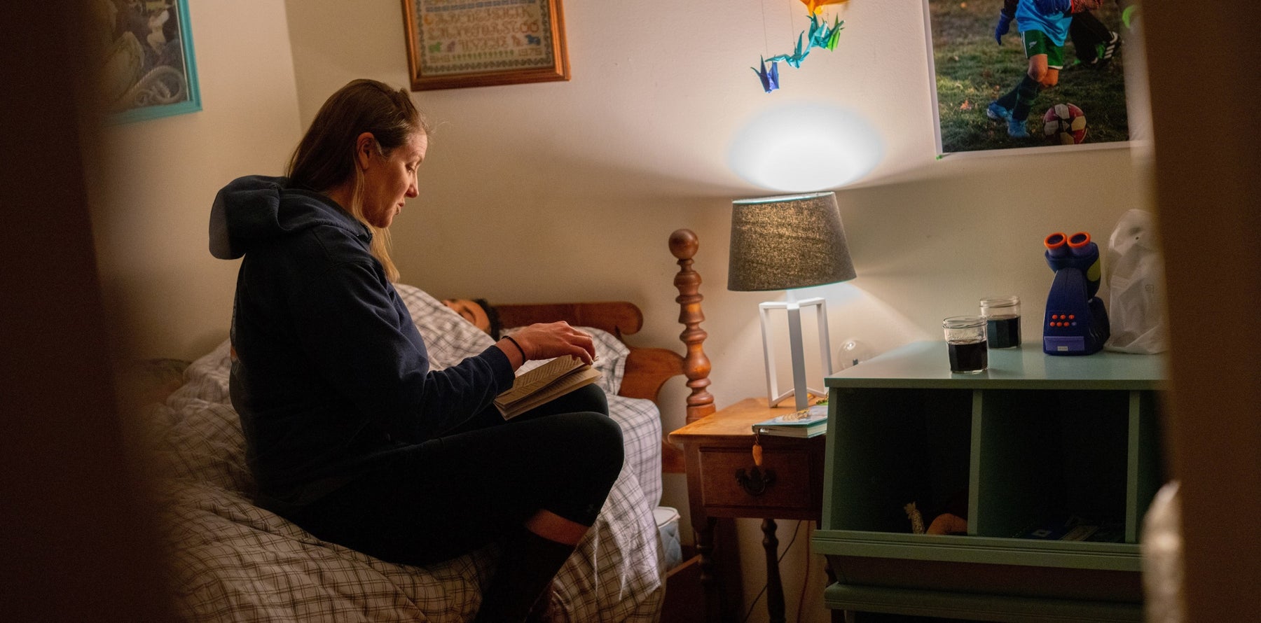 Mother reads to sleepy child laying in bed