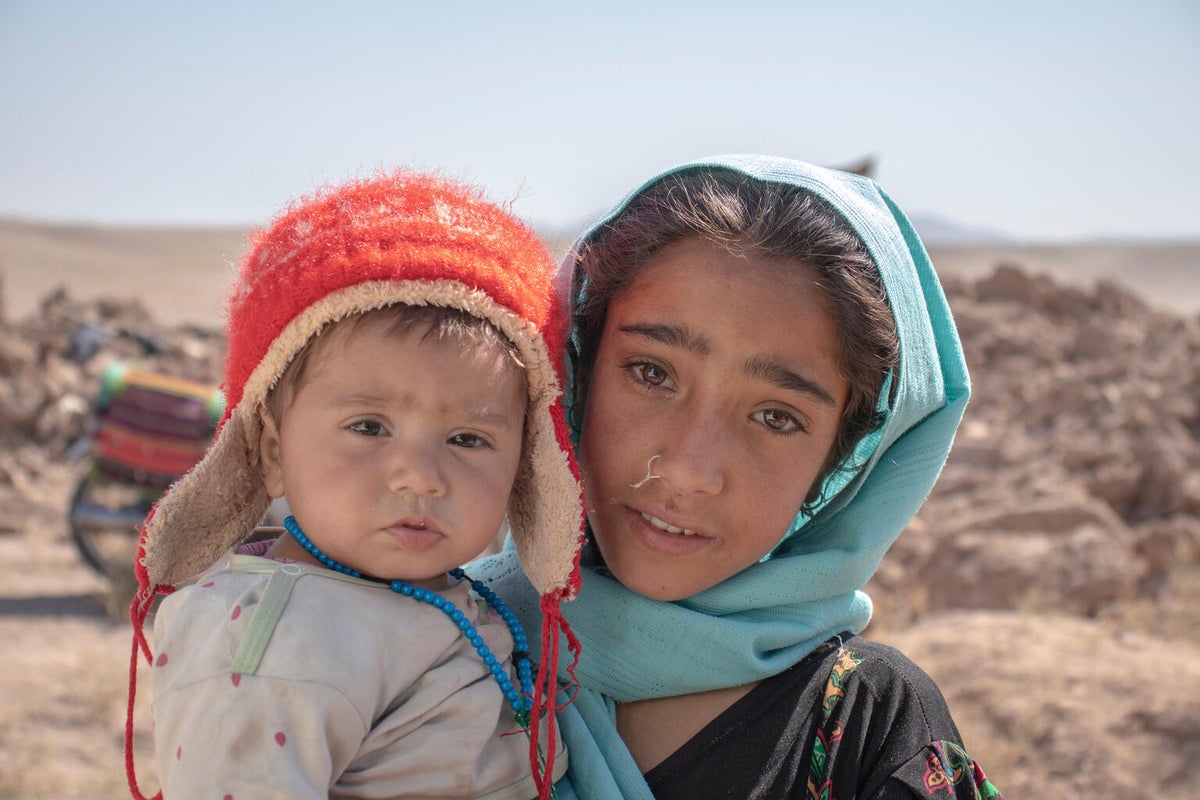 In Afghanistan, 10-year-old Zari holds her eight-month-old brother Marv in front of their collapsed house. They lost their home in the earthquake that struck the Herat Province on 7 October 2023.