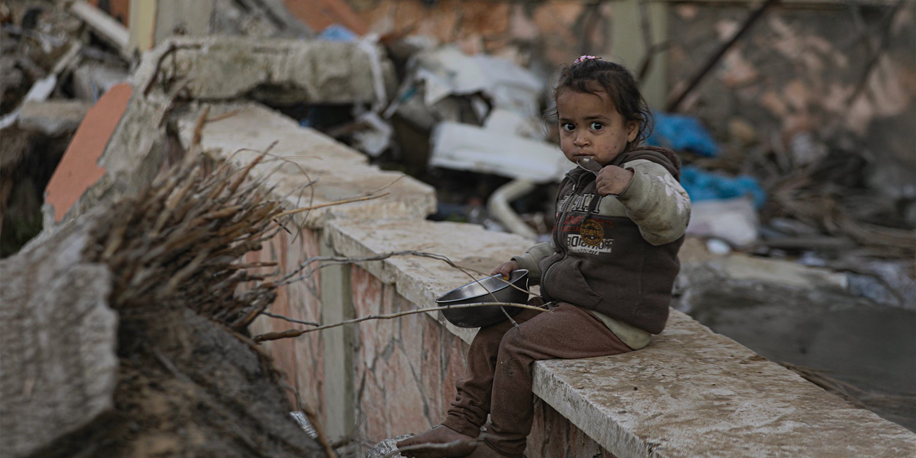 A child sits among the rubble in Gaza.
