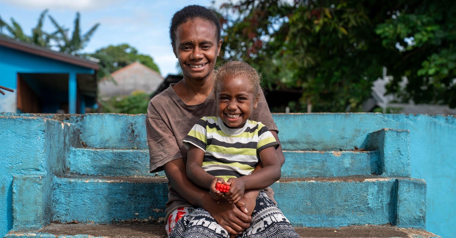A mother holds her daughter in Vanuatu.