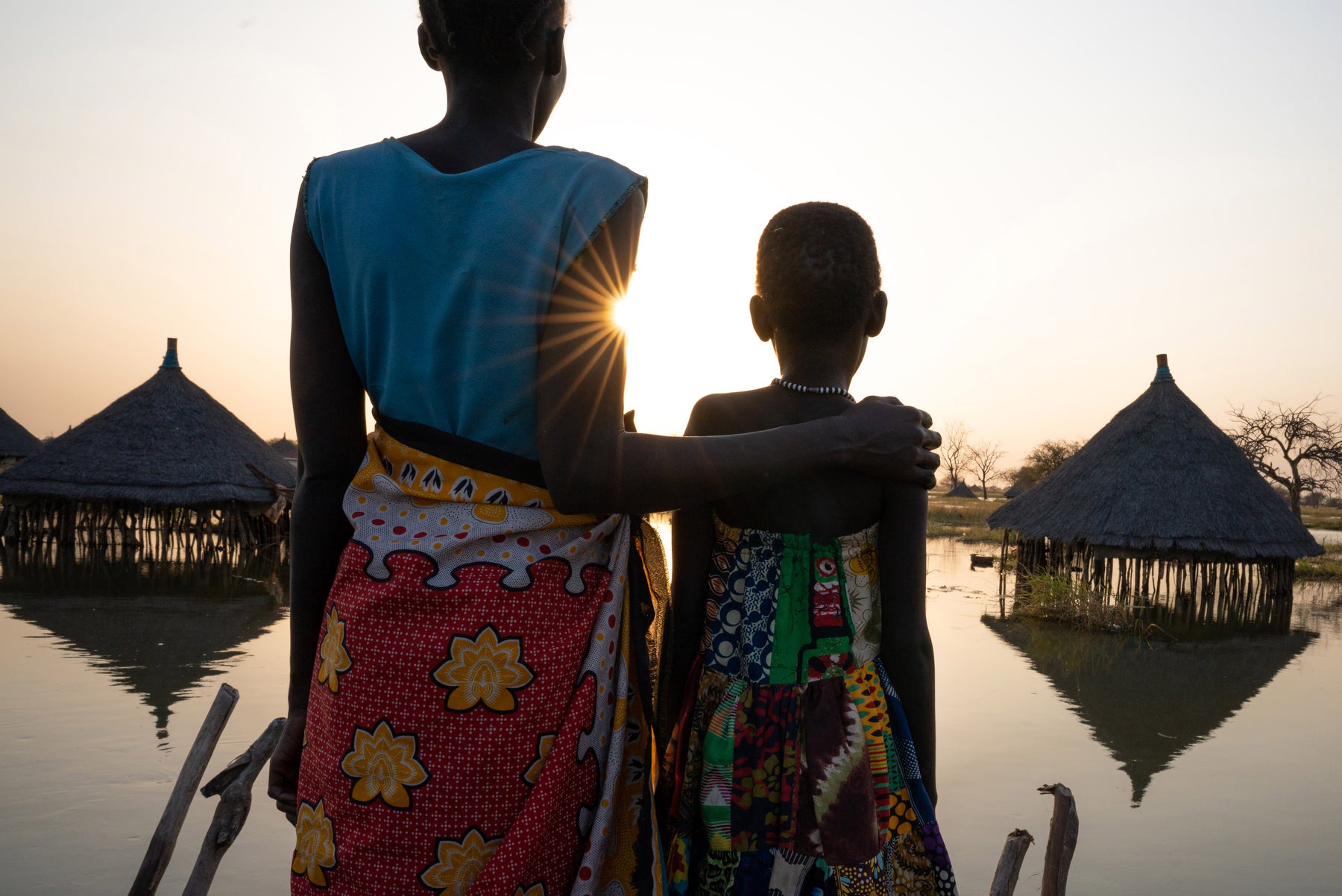 Child and adult look over flooded community